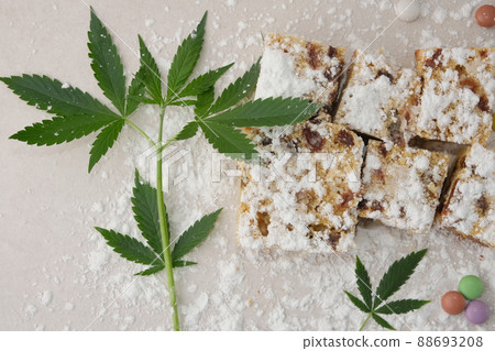 Craft cake with cannabis on light background. Layout with marijuana leaves 88693208
