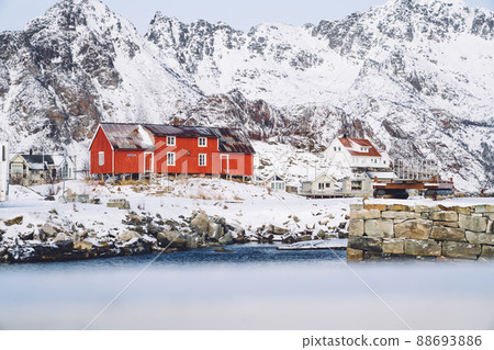 Wooden cottage in village on snowy shore Wooden cottage in village on snowy shore 88693886