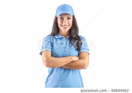 Dark-haired widely smiling woman standing in blue cap and t-shirt with hands crossed over chest. Isolated background Dark-haired widely smiling woman standing in blue cap and t-shirt with hands crossed over chest. Isolated background 88694062