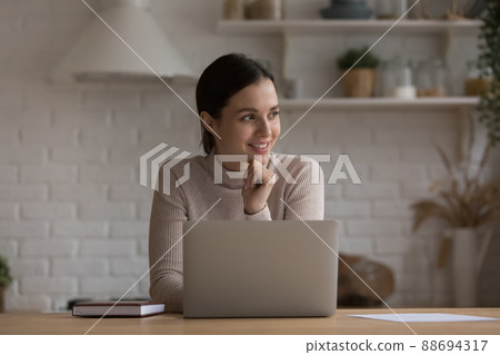Happy freelance employee woman working at home kitchen Happy freelance employee woman working at home kitchen 88694317