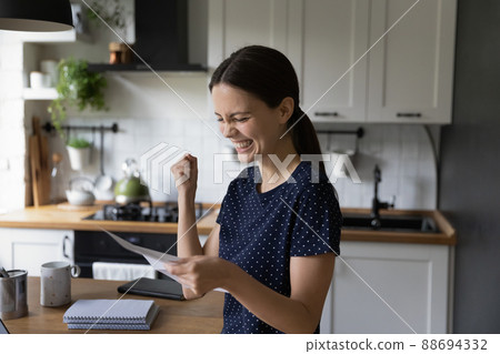 Woman read letter smiling feels satisfied by great news Woman read letter smiling feels satisfied by great news 88694332