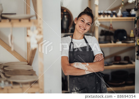 Portrait of Cheerful Potter, Female Entrepreneur in Her Clay Studio, Woman Happy Owner of a Small Pottery Business Portrait of Cheerful Potter, Female Entrepreneur in Her Clay Studio, Woman Happy Owner of a Small Pottery Business 88694354