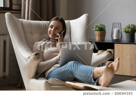 Positive busy young entrepreneur woman resting in armchair 88694393