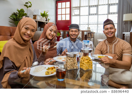 friend having iftar dinner together while sitting on the floor in the livingroom 88696440