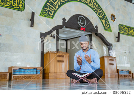 Man muslim doing prayer in the mosque and reading quran Man muslim doing prayer in the mosque and reading quran 88696532