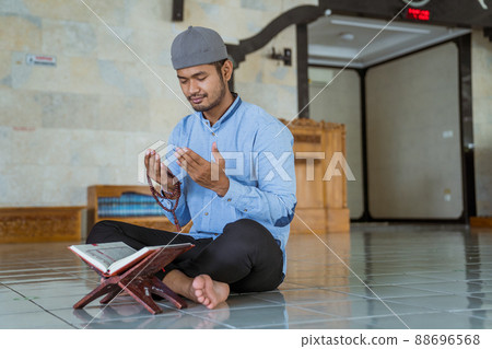 Man muslim doing prayer in the mosque and reading quran 88696568