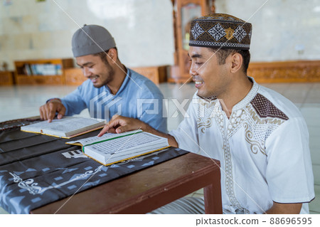 Man muslim learing to reading quran together during ramadan Man muslim learing to reading quran together during ramadan 88696595