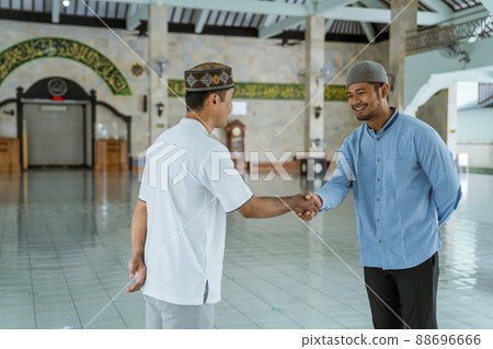 muslim people shaking hand at the mosque 88696666