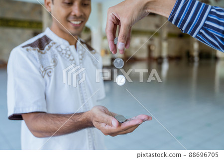 muslim paying some zakat charity using cash at the mosque muslim paying some zakat charity using cash at the mosque 88696705