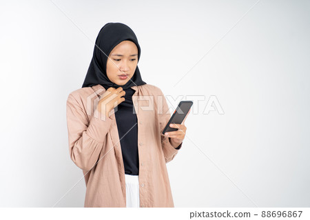 shocked muslim woman in hijab using a cell phone shocked muslim woman in hijab using a cell phone 88696867