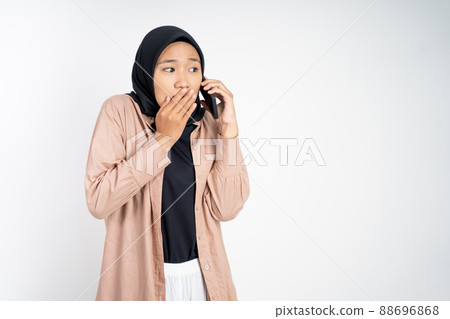 muslim woman in hijab whispering while calling on phone muslim woman in hijab whispering while calling on phone 88696868