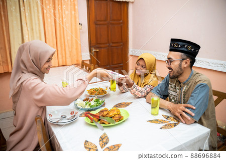 muslim mother serving some food for family dinner muslim mother serving some food for family dinner 88696884