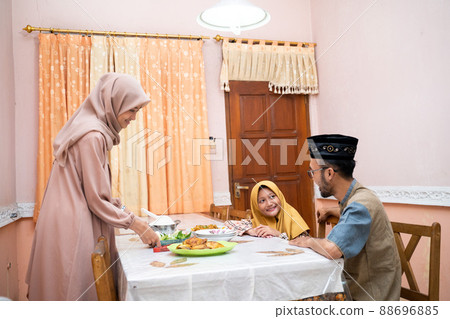 muslim mother serving some food for family dinner 88696885