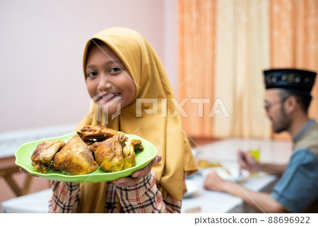 muslim mother serving some food for family dinner 88696922