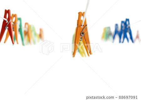 White background with hanging multi-colored clothespins for drying clothes. white background. copy space White background with hanging multi-colored clothespins for drying clothes. white background. copy space 88697091