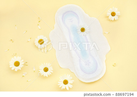 Women's absorbent soft hygienic protective pads with soothing chamomile extract during menstruation on a yellow background with flowers. gynecological menstruation cycle. flower on menstrual napkin Women's absorbent soft hygienic protective pads with soothing chamomile extract during menstruation on a yellow background with flowers. gynecological menstruation cycle. flower on menstrual napkin 88697194