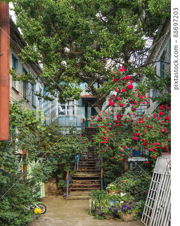 Backyard of old house in Krasnodar. Old fashioned architecture and small garden of apartment building. Russia. 88697203
