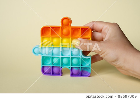 In the female hand, the popular popit toy. Anti-stress toy. entertaining games for children and adults. simple dimple. Women's nails of different colors. Colorful summer manicure. In the female hand, the popular popit toy. Anti-stress toy. entertaining games for children and adults. simple dimple. Women's nails of different colors. Colorful summer manicure. 88697309