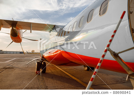 Passenger airplane under cloudy sky at airport 88698841