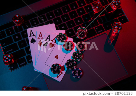 Red dices, playing chips and cards are on laptop. Poker or casino online concept. Top view 88701153