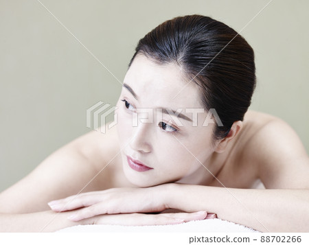portrait of beautiful young asian woman lying on front on bed portrait of beautiful young asian woman lying on front on bed 88702266
