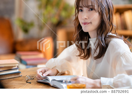 A woman reading a book over a cup of tea in a chic living room 88702691
