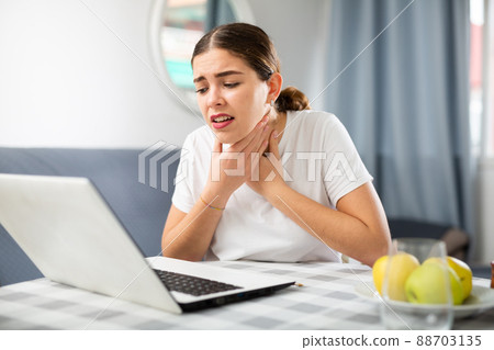 Young girl tells the doctor by video link that she has a sore throat Young girl tells the doctor by video link that she has a sore throat 88703135