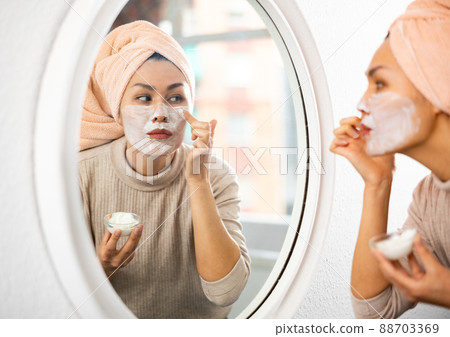 Asian woman makes a cosmetic face mask 88703369