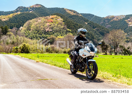 Spring bike touring and rider Satoyama where young leaves and flowers sprout f-1 Diagonal front line of sight left 88703458