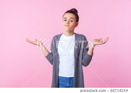 I don't know. Portrait of confused brunette teenage girl with bun hairstyle in casual clothes shrugging shoulders with no idea gesture, clueless embarrassed face. indoor studio shot, pink background I don't know. Portrait of confused brunette teenage girl with bun hairstyle in casual clothes shrugging shoulders with no idea gesture, clueless embarrassed face. indoor studio shot, pink background 88714254