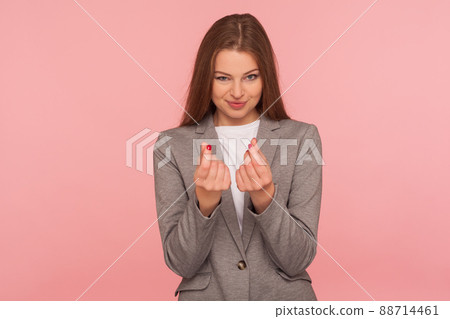 Portrait of attractive cunning young woman in business suit showing money gesture and looking slyly, demanding investments, dreaming of financial profit. studio shot isolated on pink background Portrait of attractive cunning young woman in business suit showing money gesture and looking slyly, demanding investments, dreaming of financial profit. studio shot isolated on pink background 88714461