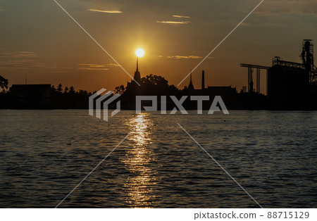 Gorgeous scenic of Thai temple silhouettes and Industrial factory along Chao phraya river over sun at sunrise. 88715129