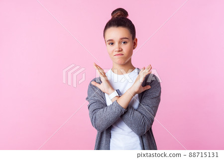 No way, finish. Portrait of displeased brunette teenage girl with bun hairstyle in casual clothes crossing hands, showing stop x sign denial gesture. indoor studio shot isolated on pink background No way, finish. Portrait of displeased brunette teenage girl with bun hairstyle in casual clothes crossing hands, showing stop x sign denial gesture. indoor studio shot isolated on pink background 88715131