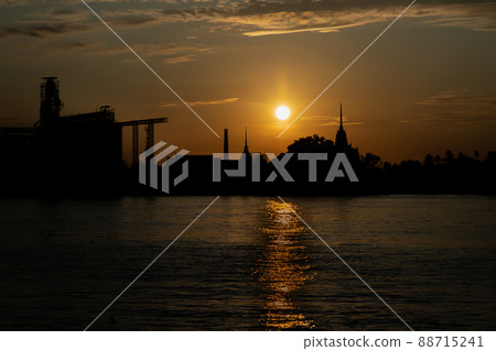 Gorgeous scenic of Thai temple silhouettes and Industrial factory along Chao phraya river over sun at sunrise. Gorgeous scenic of Thai temple silhouettes and Industrial factory along Chao phraya river over sun at sunrise. 88715241
