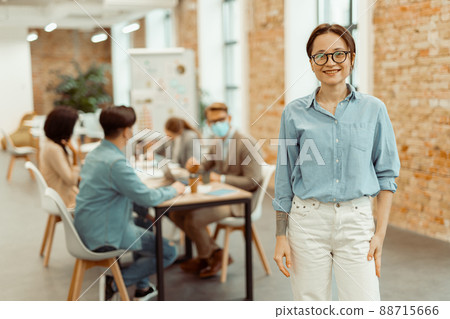 Pretty young woman standing in the office Pretty young woman standing in the office 88715666