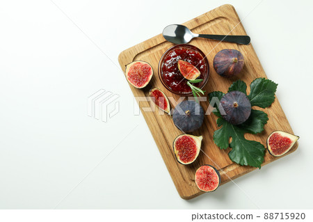Board with fig jam, ingredients and spoon on white background 88715920