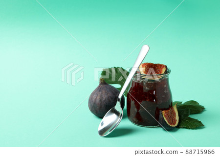 Jar with fig jam, ingredients and spoon on mint background 88715966