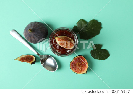 Jar with fig jam, ingredients and spoon on mint background 88715967