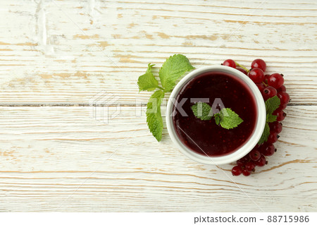 Bowl of cranberry sauce on white wooden background 88715986