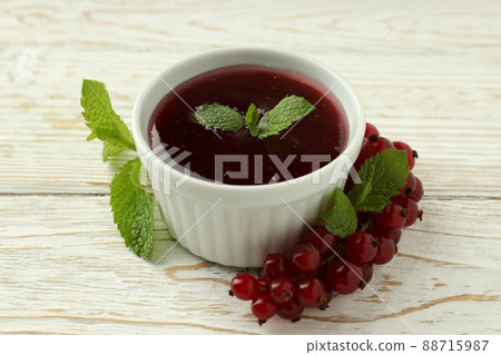 Bowl of cranberry sauce on white wooden background 88715987