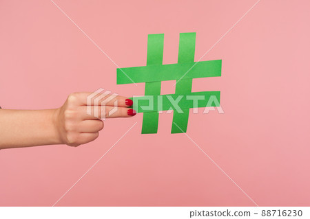 Blog marketing, social media trends. Closeup of female hand holding green hashtag sign, sharing tagged message, famous internet post, promoting web content and viral ideas. indoor studio shot isolated Blog marketing, social media trends. Closeup of female hand holding green hashtag sign, sharing tagged message, famous internet post, promoting web content and viral ideas. indoor studio shot isolated 88716230