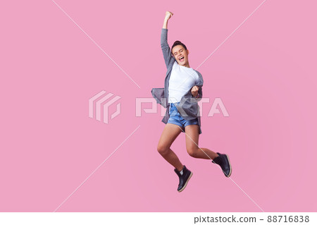 I did it. Energetic teen girl with bun hairstyle in casual clothes jumping with closed eyes and raised fists, crazy about winning, screaming and dancing with happiness in the air, celebrating success I did it. Energetic teen girl with bun hairstyle in casual clothes jumping with closed eyes and raised fists, crazy about winning, screaming and dancing with happiness in the air, celebrating success 88716838
