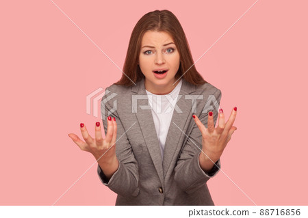 What's the problem. Portrait of irritated indignant young woman in business suit raising hands in anger and shouting why how, what do you want, quarreling. studio shot isolated on oink background What's the problem. Portrait of irritated indignant young woman in business suit raising hands in anger and shouting why how, what do you want, quarreling. studio shot isolated on oink background 88716856