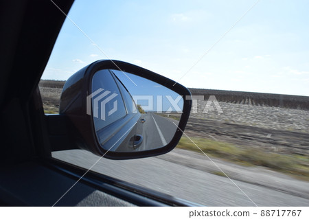 Reflected road in rearview mirror. View from car side mirror driving on asphalt road. 88717767
