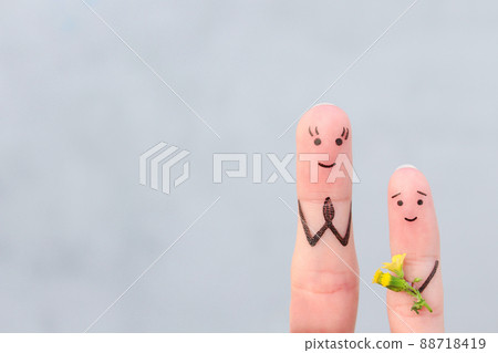 Fingers art of happy people. Concept of child gives his mother a flower. Mother's Day. Knowledge Day 88718419