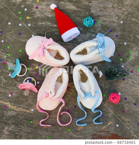2022 new year written laces of children's shoes and pacifier on old wooden background.  88718481