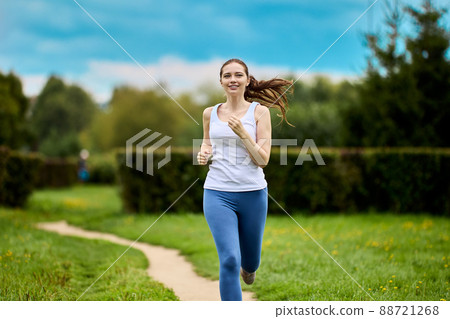 Jogging in city park by happy woman at summer. Jogging in city park by happy woman at summer. 88721268