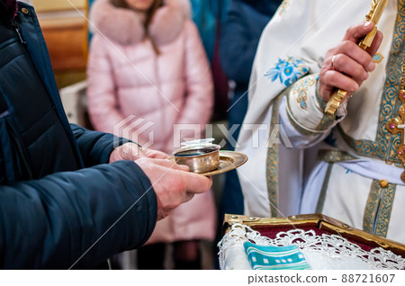 Man holding church silver chalice with wine on the silver plate 88721607