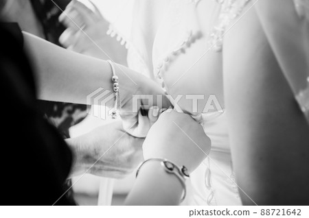 Bridesmaids assist bride to wear wedding dress black and white Bridesmaids assist bride to wear wedding dress black and white 88721642