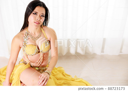 Berry dancer in yellow costume sitting on the floor looking up at the camera Berry dancer in yellow costume sitting on the floor looking up at the camera 88723173